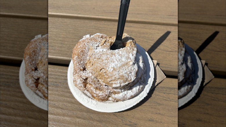 A Root Beer Float Cream Puff from Schmidt's Sausage Haus in Ohio on white plate with black fork stuck inside.