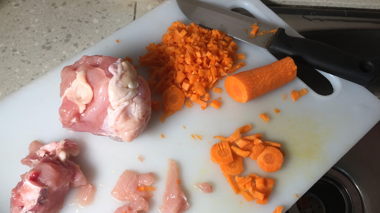 chicken, carrots on cutting board