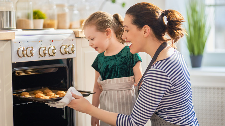 woman taking cookies from oven