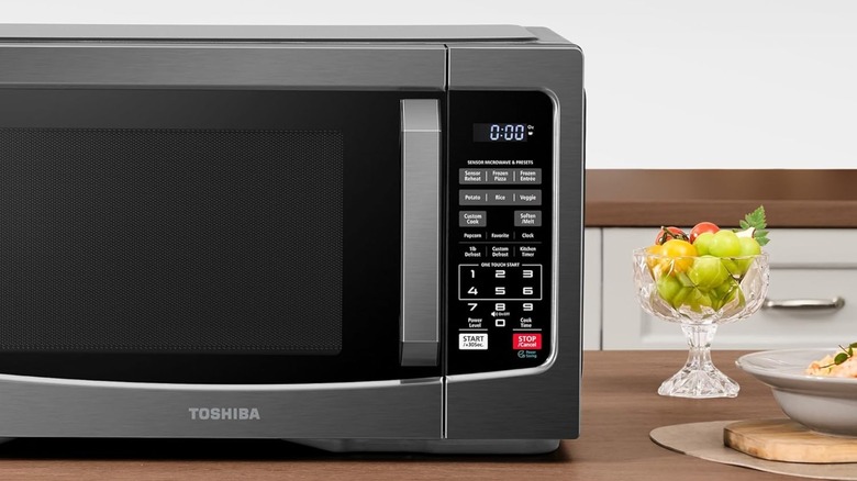 Toshiba microwave on table with bowl of fruit