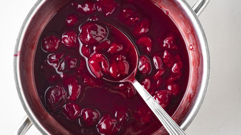 canned cherries being lifted with spoon