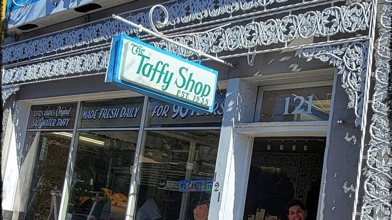 Outside of a candy store with a sign that says The Taffy Shop