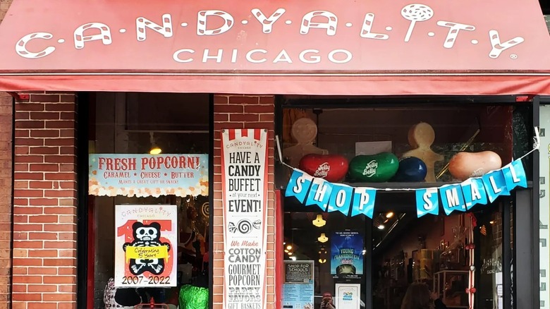 The outside of a candy store with fresh popcorn and candy buffet signage