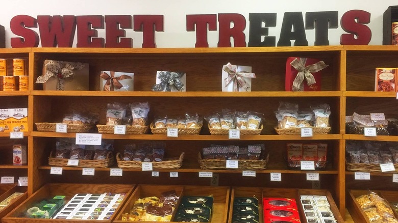 Various candies on shelves with a sweet treats sign