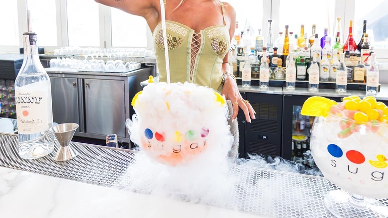A woman making cocktails at a bar counter