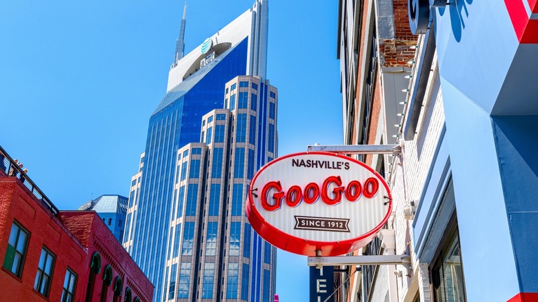 A sign saying Goo Goo in front of a city skyline