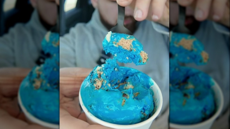 Spooning blue Cookie Monster ice cream out of tub
