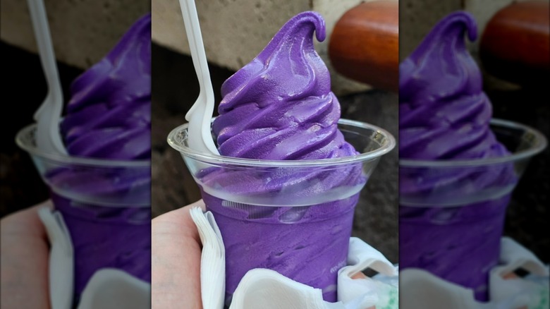 Swirl of purple ube ice cream in plastic cup with spoon