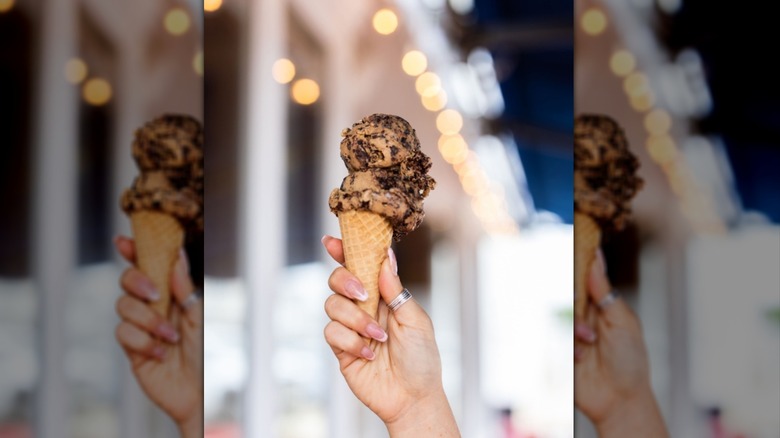 Hand holding cone filled with Mississippi mud ice cream