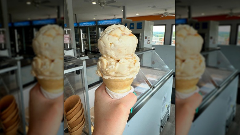 Hand holding cone filled with butter brickle ice cream