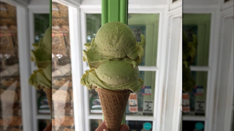 Hand holding cone filled with pistachio ice cream