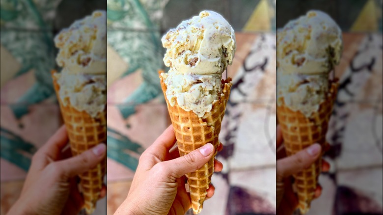 Hand holding cone filled with key lime pie ice cream