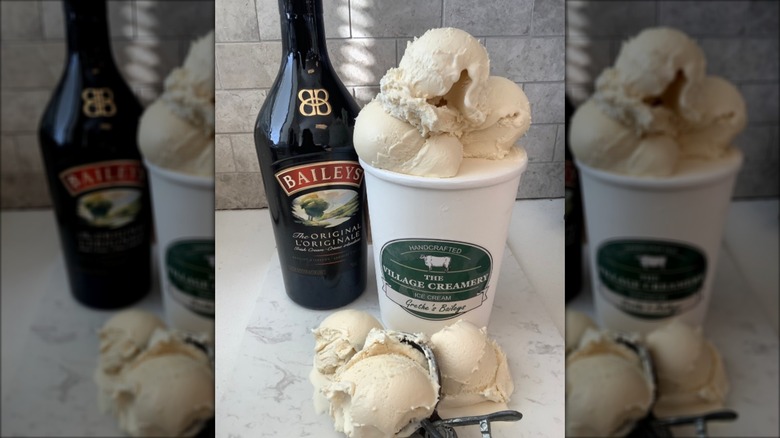Tub and scoop filled with Bailey's ice cream, next to bottle of Bailey's