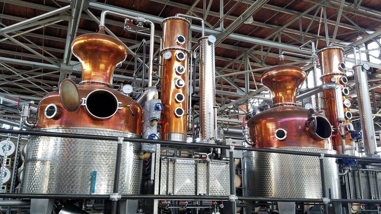 Copper distillation tanks in an aircraft hangar turned distillery.