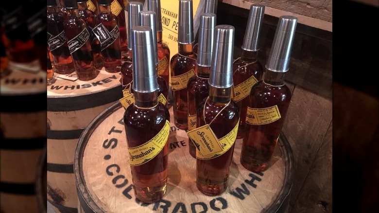 Retail display of bottles of Stranahan's with steel shot glasses on bottle neck.
