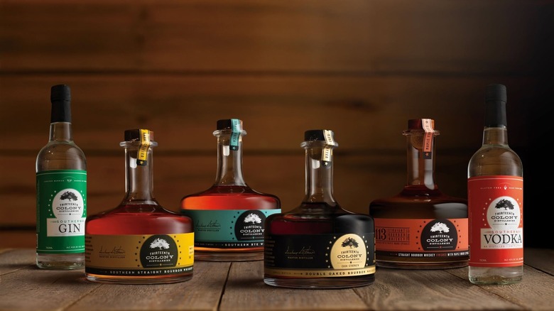 A suite of 13th Colony spirit bottles on wood table.