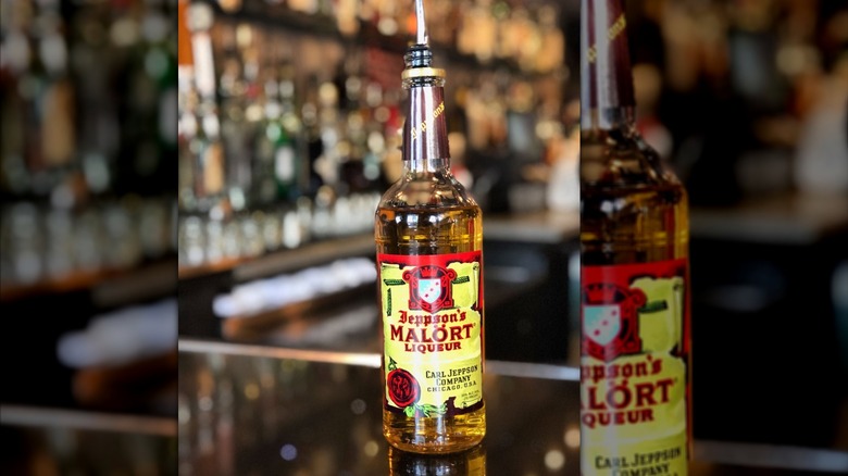 A bottle of Malort with a speedpour on a bartop.