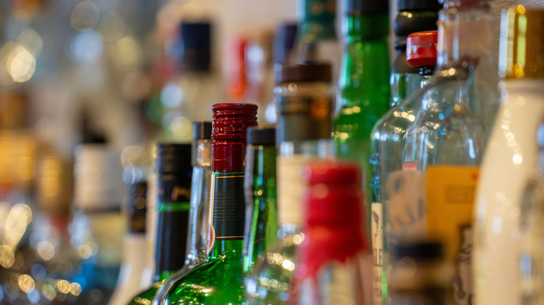 Assorted liquor bottles on a bar shelf.