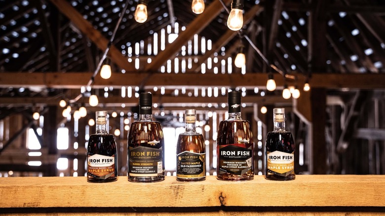 A suite of Iron Fish products on a wooden railing in a barn with light coming through the boards.