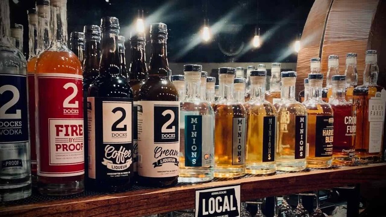 A row of various liquor bottles on a bar shelf with Fire by Proof and Coffee and Cream Liqueurs at the fore.