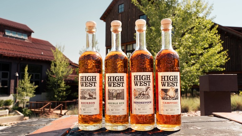 Four bottles of High West whiskeys of differing expressions on a table outside.