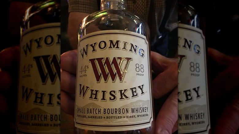 Close-up shot of Wyoming Whiskey Small Batch displayed in a man's hand.