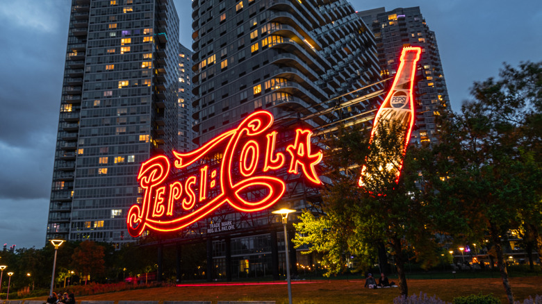A vintage-style neon sign displaying Pepsi Cola and a Pepsi bottle.