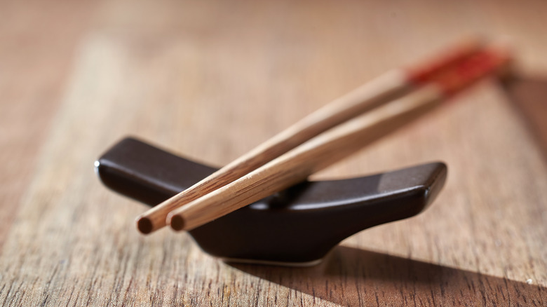 A pair of chopsticks on a chopstick rest