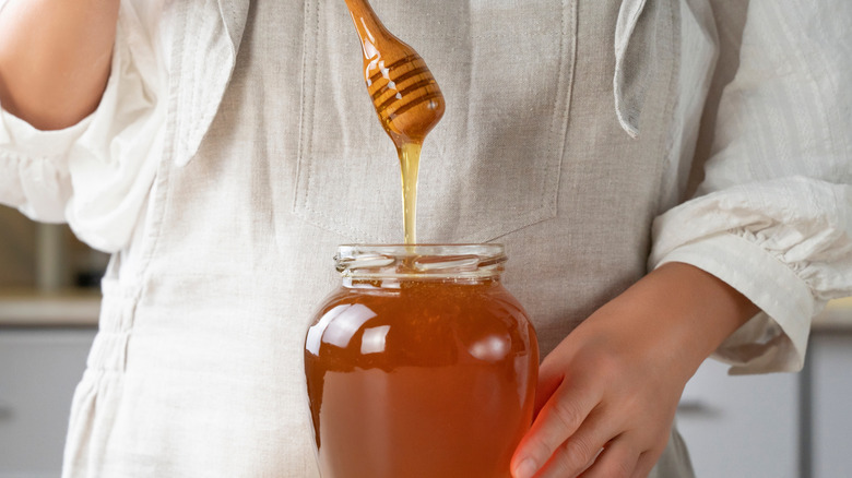 Scooping honey from jar