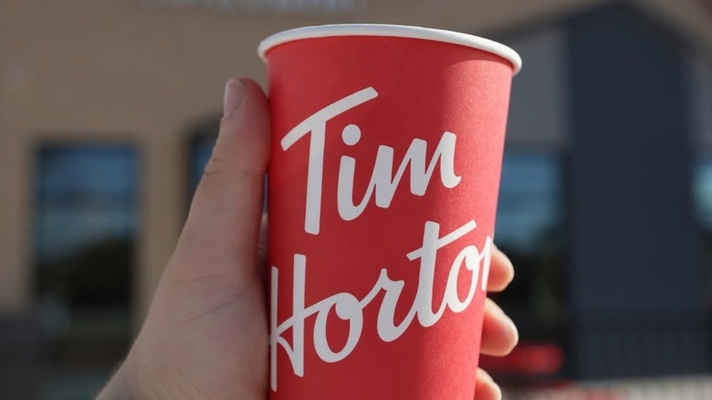 A Tim Hortons coffee cup in someone's hand