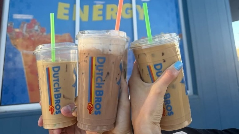 Several people holding iced coffees from Dutch Bros Coffee