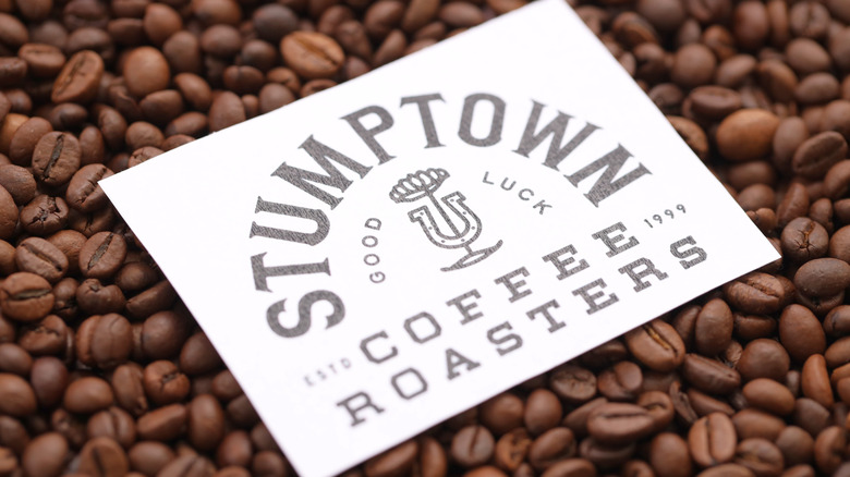 A Stumptown Coffee Roasters logo card atop a pile of coffee beans