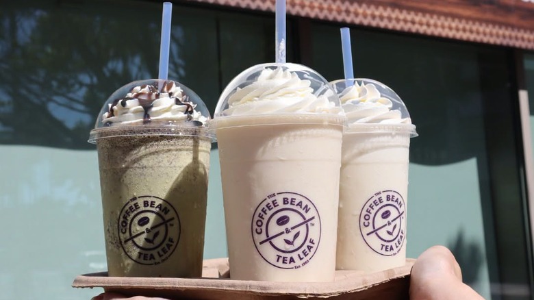 A person holding ice blended drinks from The Coffee Bean & Tea Leaf