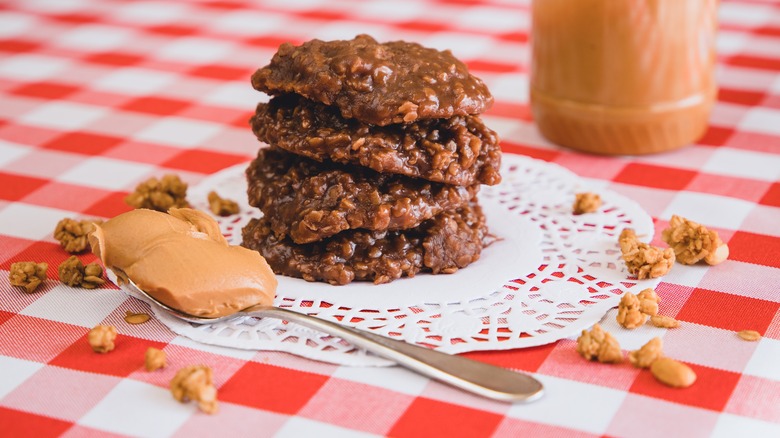 Plate of peanut butter no-bake cookies on red table cloth with spoon of peanut butter