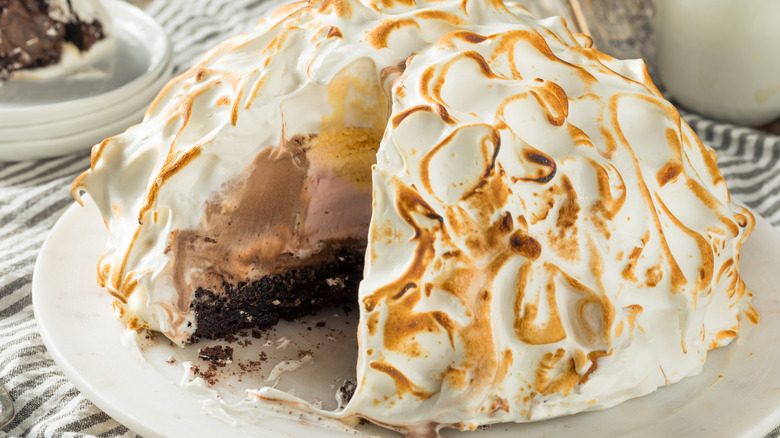 Baked Alaska on white plate on striped tablecloth