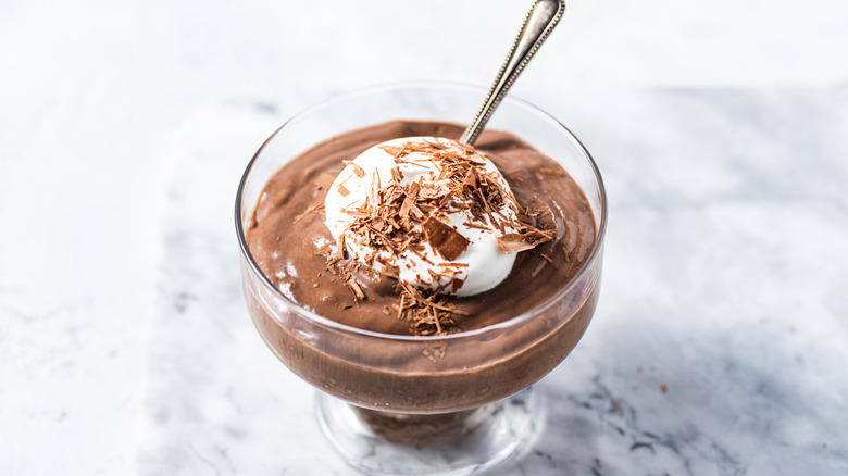 Chocolate mousse with cream in a glass dish with spoon sticking out