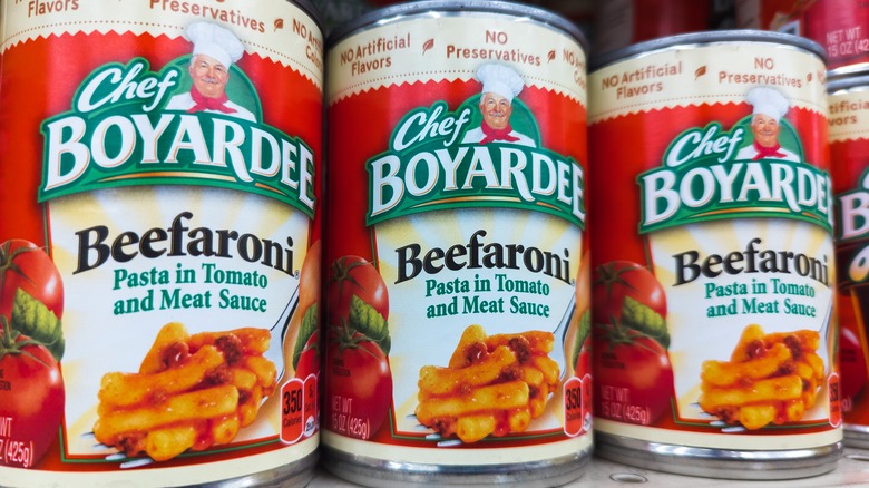 three cans of Beefaroni on store shelf