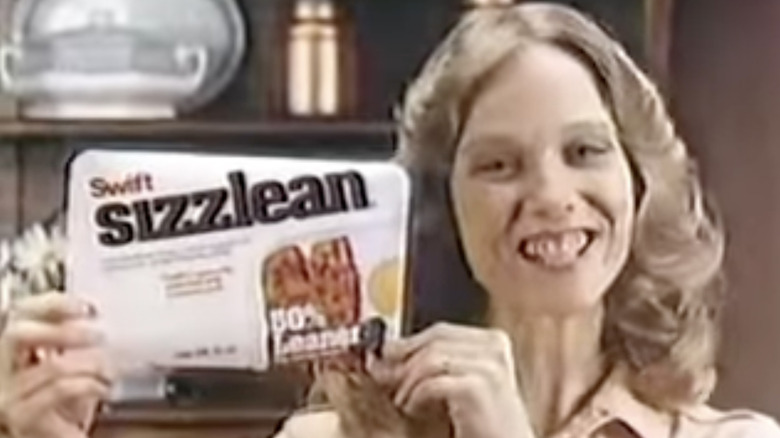 screenshot from Sizzlean ad of woman holding up packet of Sizzlean