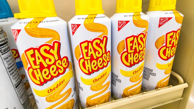 row of Spray can Easy Cheese in grocery store