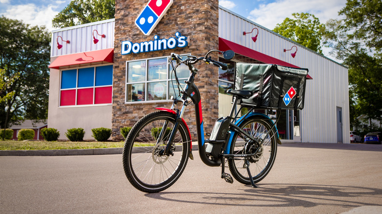 Black, red, and blue bicycle with a Domino's delivery box on the back
