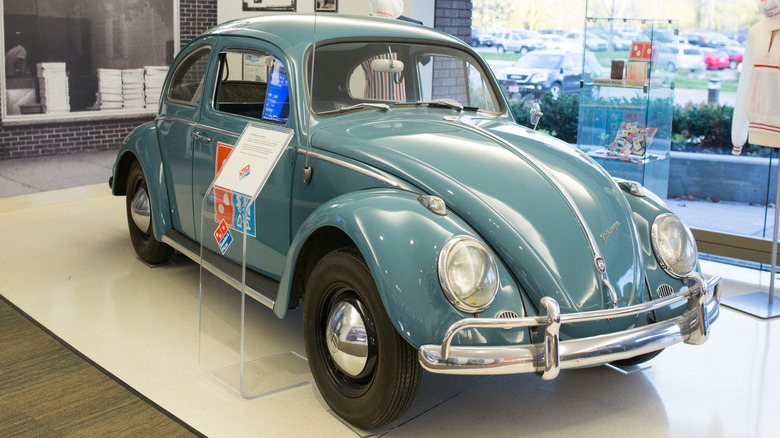 Blue Volkswagen Beetle with Domino's branding in a museum
