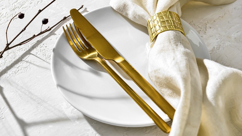 gold utensils and cloth napkin
