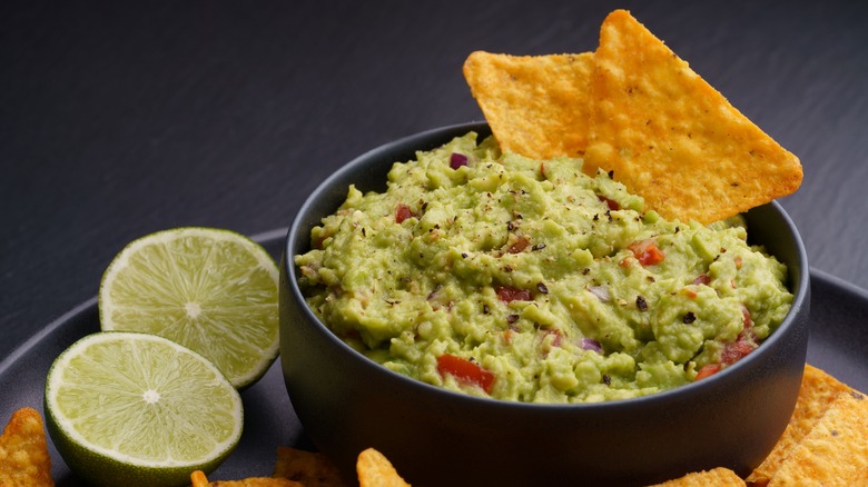 Bowl of guacamole with a chip