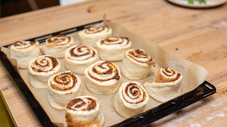 Unbaked cinnamon rolls laid out on a baking dish