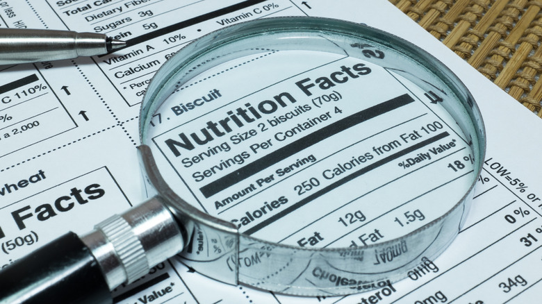 Magnifier highlighting nutritional facts sheet.
