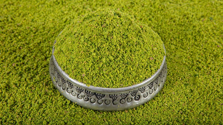 Finely chopped pistachio nuts in overflowing bowl