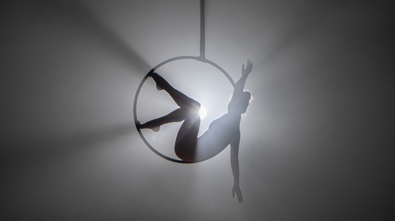 Acrobat on hoop, backlit