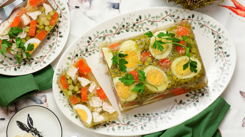 Aspic with egg and vegetables on a floral plate
