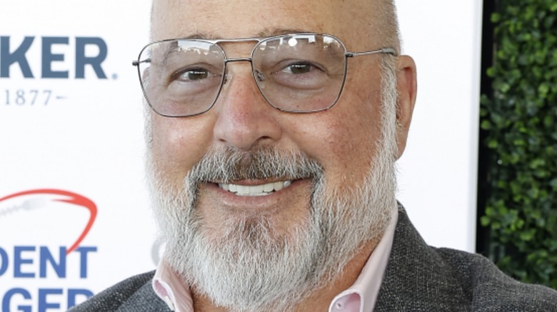 andrew zimmern smiles with glasses