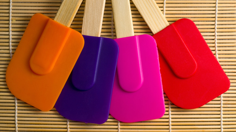 Colorful rubber spatulas on a drying rack